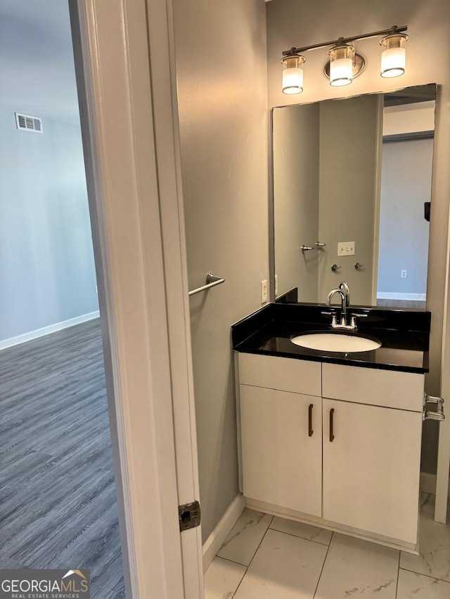 bathroom featuring visible vents, marble finish floor, vanity, and baseboards