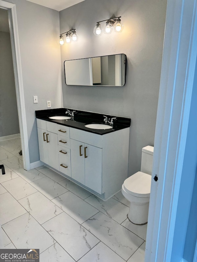 bathroom featuring baseboards, marble finish floor, vanity, and toilet