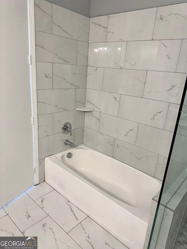 full bathroom featuring marble finish floor and shower / tub combination