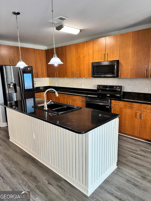 kitchen featuring brown cabinetry, visible vents, appliances with stainless steel finishes, and a sink