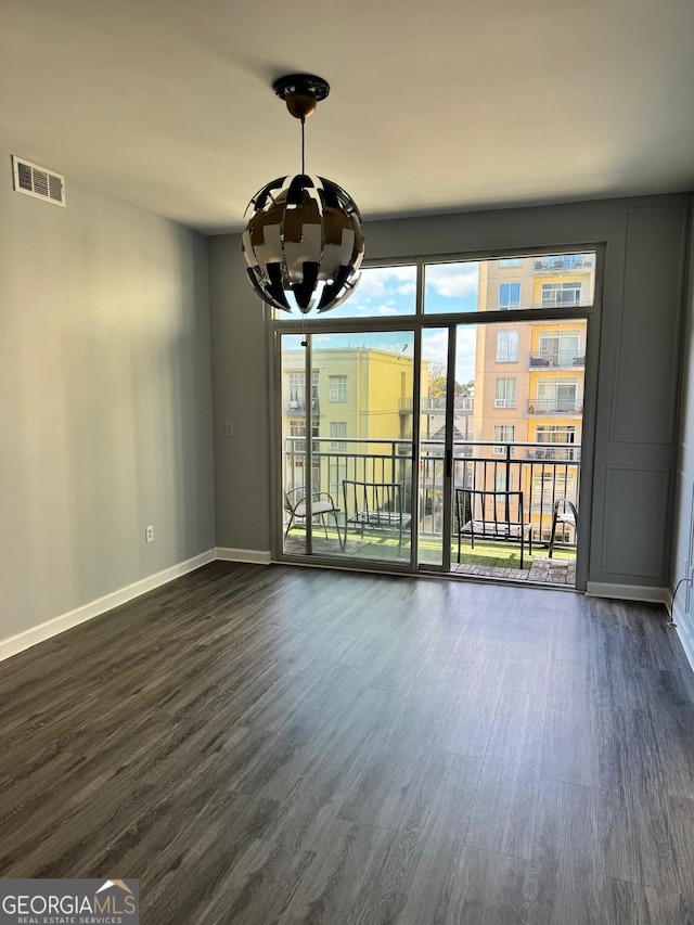 interior space with baseboards, visible vents, dark wood-style flooring, and a chandelier