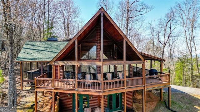 rear view of house with faux log siding and a wooden deck