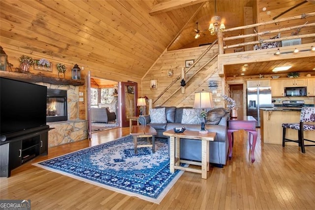 living room featuring beam ceiling, wooden walls, hardwood / wood-style floors, and high vaulted ceiling