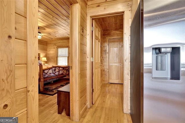 corridor with wooden ceiling, light wood-type flooring, and wood walls