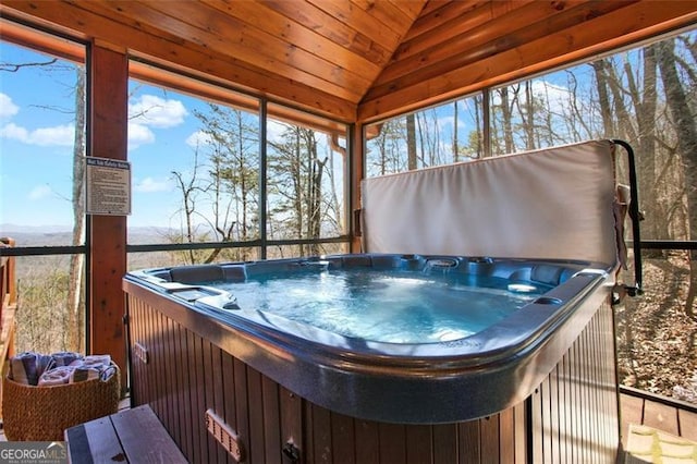 sunroom with lofted ceiling, a healthy amount of sunlight, and a hot tub