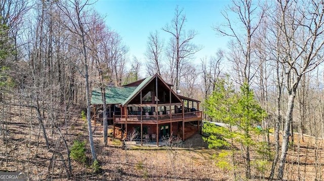 rear view of property featuring faux log siding and a deck