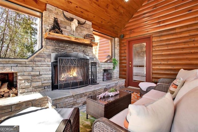 living area featuring lofted ceiling, log walls, wooden ceiling, and an outdoor stone fireplace