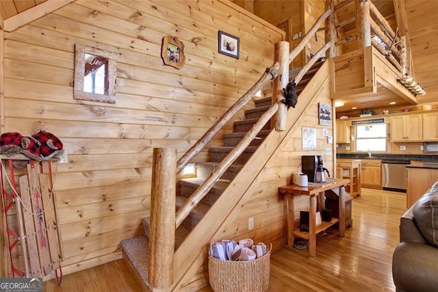 staircase with hardwood / wood-style floors, wooden ceiling, and wooden walls