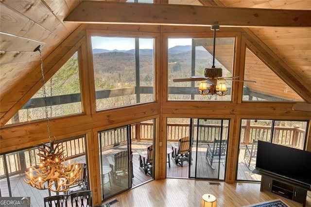 sunroom featuring lofted ceiling with beams, a healthy amount of sunlight, and visible vents