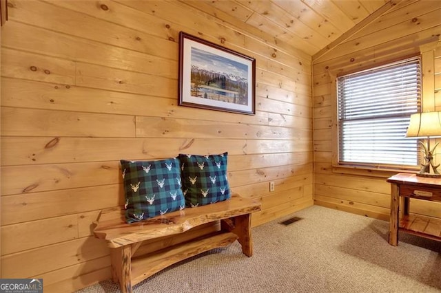 living area featuring visible vents, wooden ceiling, wood walls, carpet flooring, and lofted ceiling