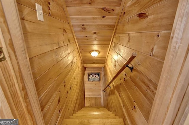 stairs featuring wooden walls and wood ceiling