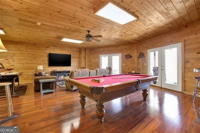 recreation room featuring wooden walls, wood finished floors, ceiling fan, french doors, and wooden ceiling