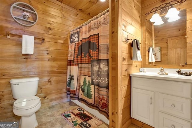 full bath with vanity, wooden walls, toilet, and curtained shower