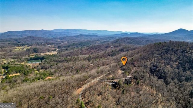 aerial view featuring a wooded view and a mountain view