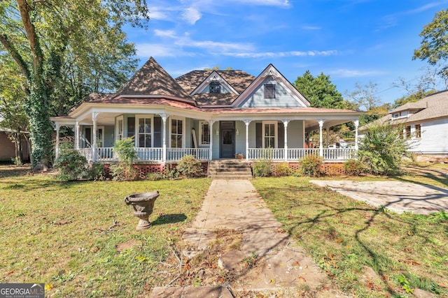 victorian house featuring covered porch and a front lawn