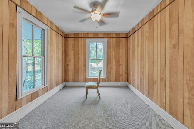 empty room featuring plenty of natural light, a ceiling fan, and light colored carpet