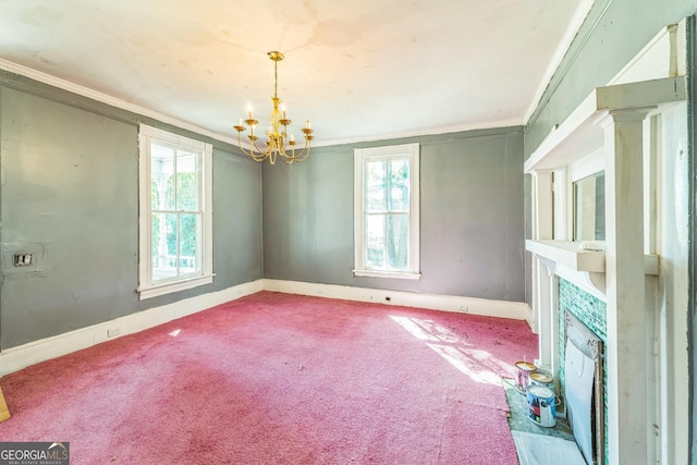 unfurnished living room featuring carpet, a healthy amount of sunlight, ornamental molding, and an inviting chandelier