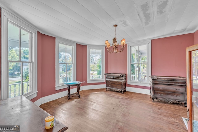 dining space featuring baseboards, a notable chandelier, a healthy amount of sunlight, and wood finished floors