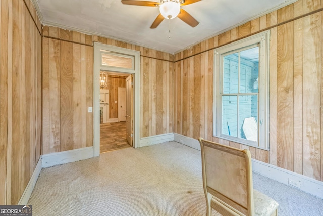 spare room with baseboards, ceiling fan, and wood walls