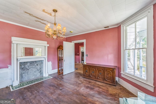 unfurnished living room featuring a chandelier, wood finished floors, baseboards, and ornamental molding