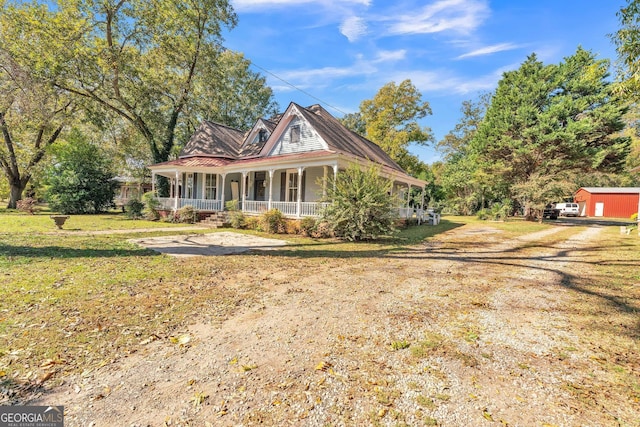 victorian home with covered porch, a front yard, and dirt driveway