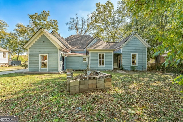 rear view of house featuring a garden, a yard, and fence