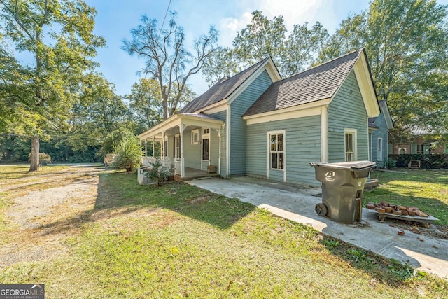 view of front of property featuring a front yard and a shingled roof