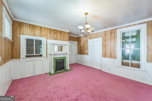 unfurnished living room featuring a fireplace with flush hearth, a notable chandelier, ornamental molding, and carpet