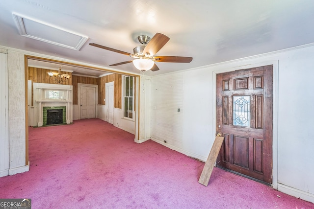 unfurnished living room with carpet flooring, a fireplace with flush hearth, crown molding, and ceiling fan