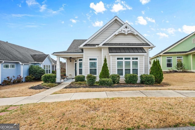 view of front of property featuring a front lawn and roof with shingles