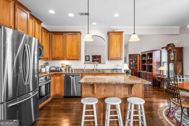 kitchen featuring a center island, brown cabinets, stainless steel appliances, and a sink