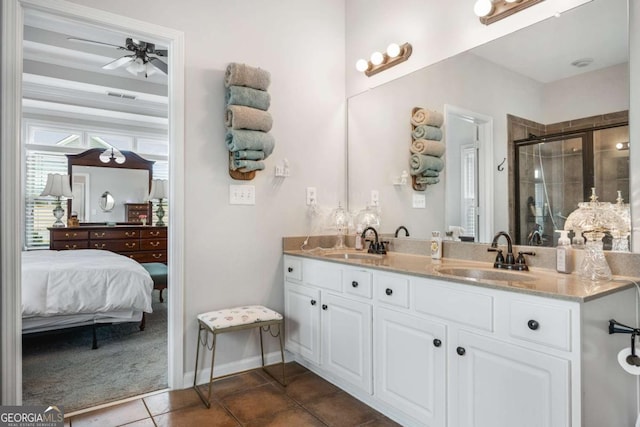 ensuite bathroom with a sink, ceiling fan, a shower stall, and tile patterned floors