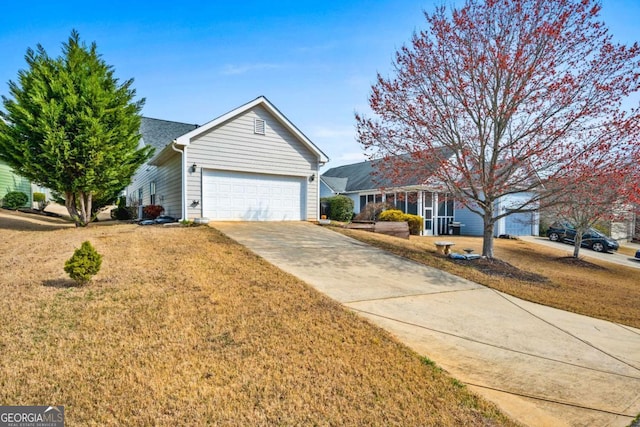 view of front of house with an attached garage, concrete driveway, and a front lawn