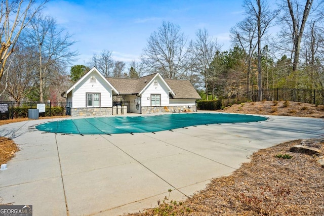 pool with a patio area and fence