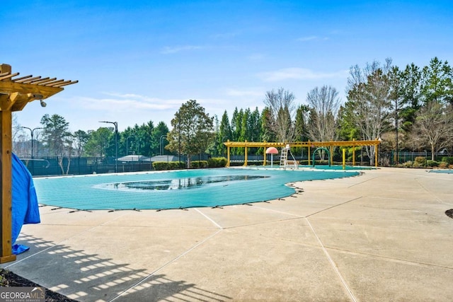 pool with a patio area, a pergola, and fence