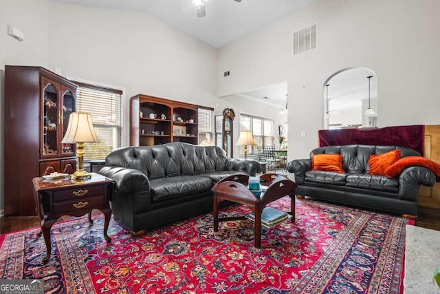 living room featuring visible vents, high vaulted ceiling, wood finished floors, and a ceiling fan