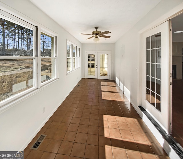 unfurnished sunroom with visible vents, ceiling fan, and french doors