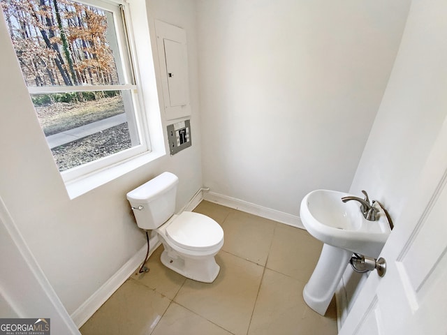 bathroom featuring tile patterned floors, toilet, electric panel, and baseboards