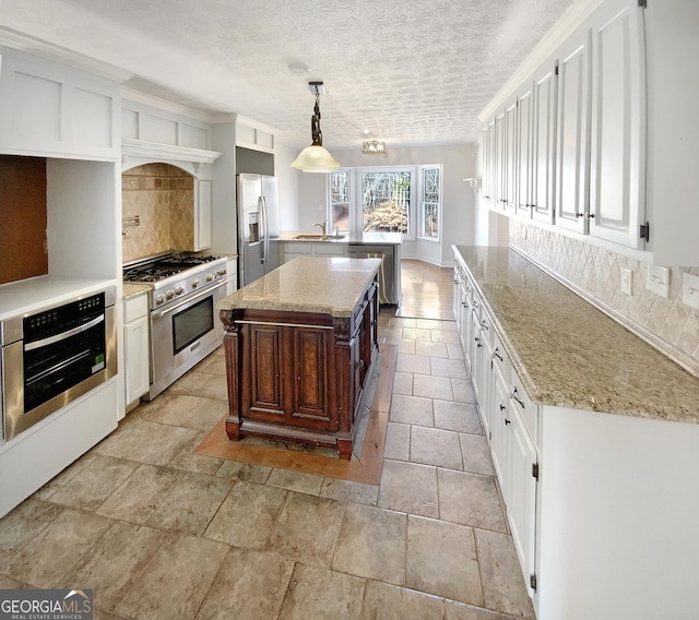 kitchen with tasteful backsplash, white cabinetry, stainless steel appliances, and a sink