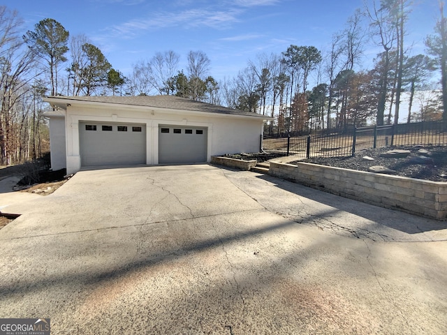 garage with driveway and fence