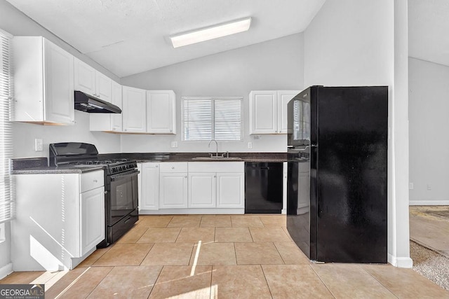 5338 Timor Trl, Lithonia, GA 30038 - kitchen with black appliances, under cabinet range hood, lofted ceiling, dark countertops, and white cabinetry