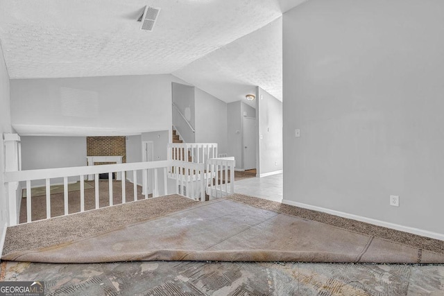 5338 Timor Trl, Lithonia, GA 30038 - spare room with a textured ceiling, stairway, lofted ceiling, and a fireplace