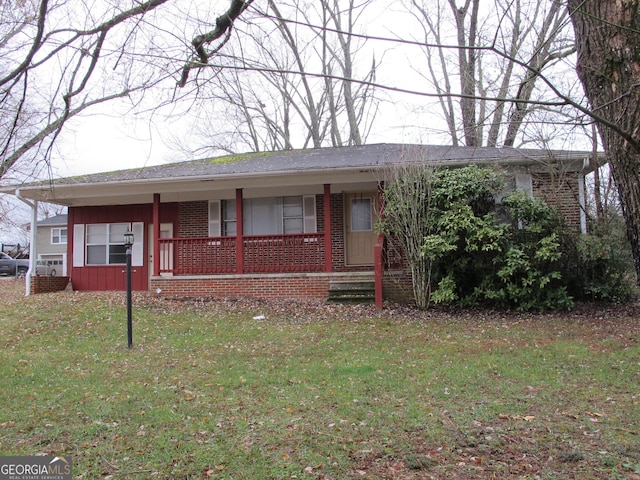 ranch-style house featuring board and batten siding, brick siding, covered porch, and a front lawn