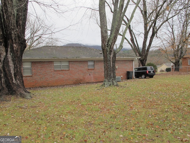 view of home's exterior with brick siding and a yard