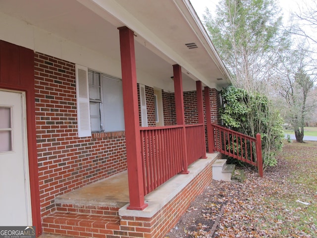 exterior space with brick siding and a porch