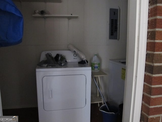 clothes washing area with electric panel, washer / dryer, and laundry area