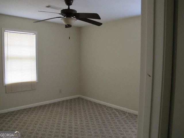 unfurnished room featuring baseboards, carpet floors, and a ceiling fan