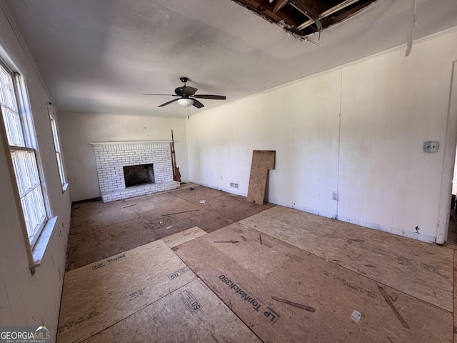 unfurnished living room with visible vents, ceiling fan, and a fireplace