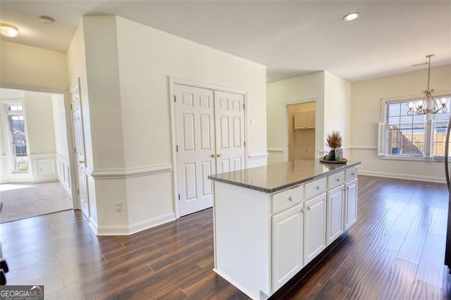 915 Cruce Lake Dr, Hoschton, GA 30548 - kitchen featuring dark stone countertops, a kitchen island, dark wood-style floors, a chandelier, and hanging light fixtures