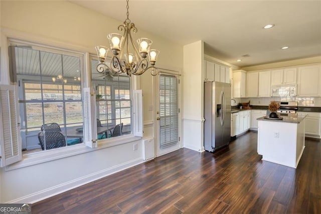 915 Cruce Lake Dr, Hoschton, GA 30548 - kitchen featuring dark countertops, appliances with stainless steel finishes, an inviting chandelier, dark wood-style floors, and white cabinetry